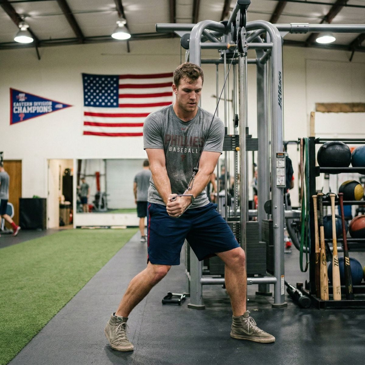 Man exercising in a gym with an American flag in the background
